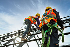 Mannen die op hoogte werken en PBM en CBM dragen