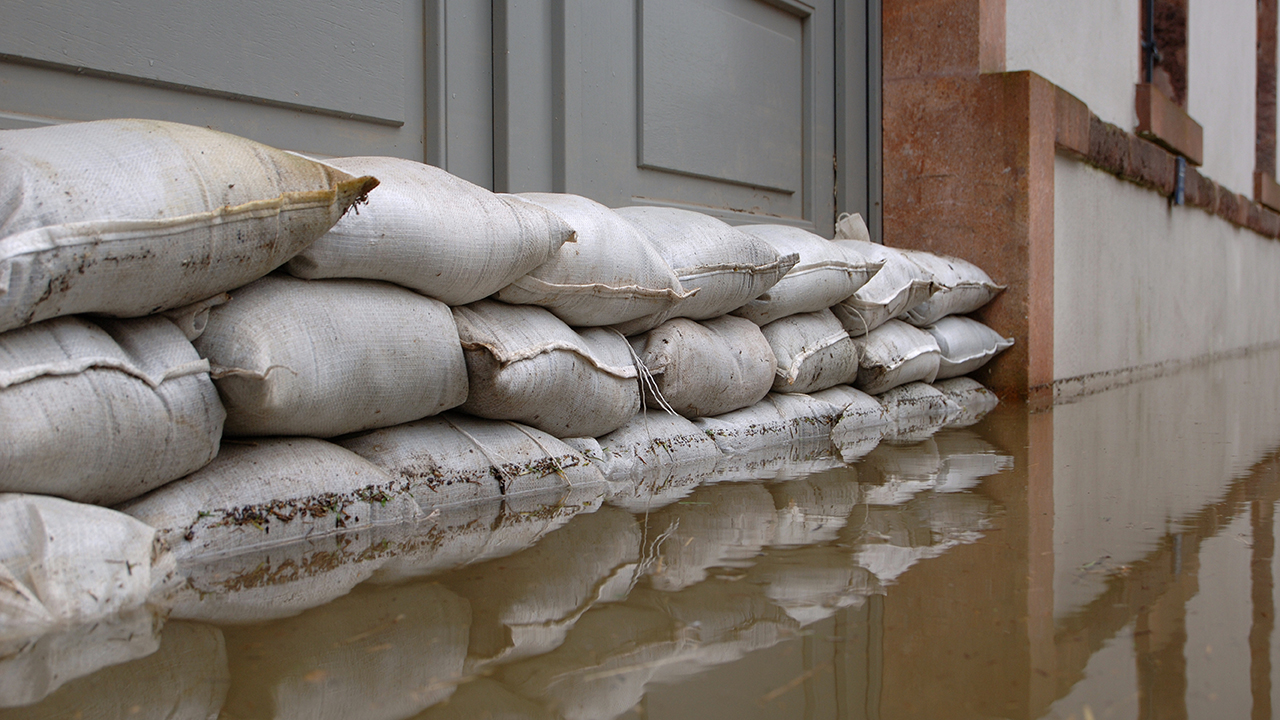 Stormpreventie zandzakjes voor deur leggen